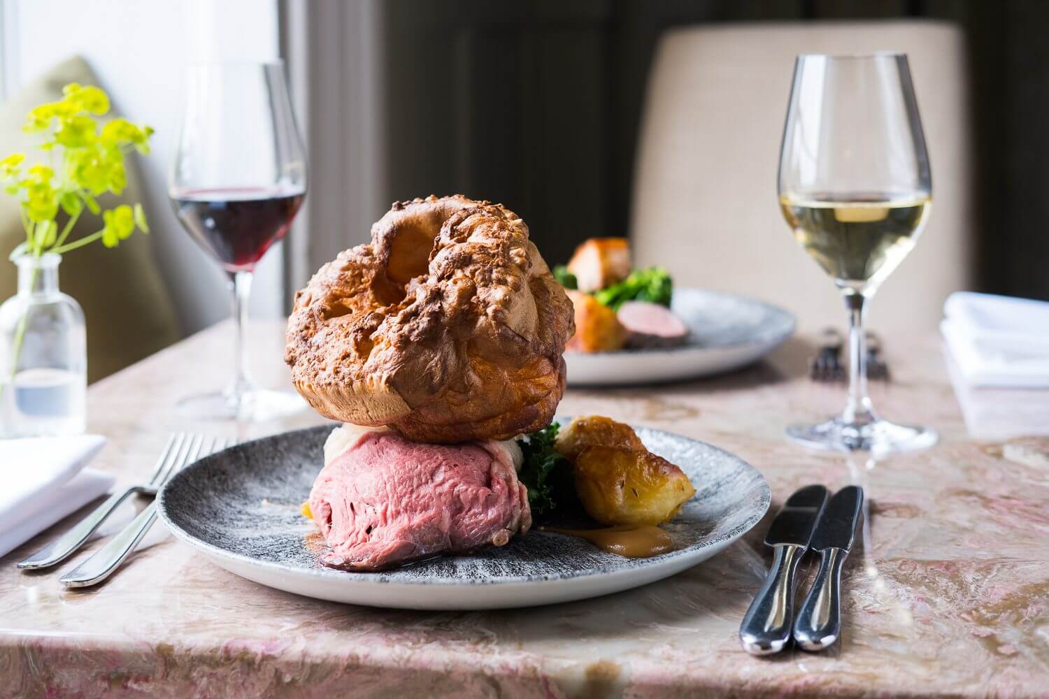 Rare roast beef on a plate with a large Yorkshire pudding at Burleigh Court