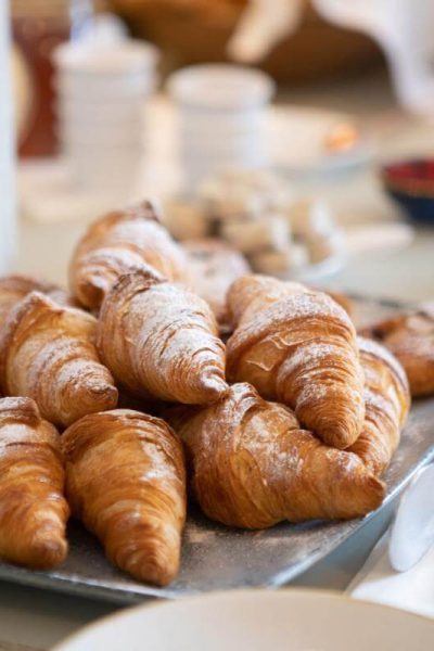 Plate of fresh croissants with butter and preserves on a side table at Burleigh Court